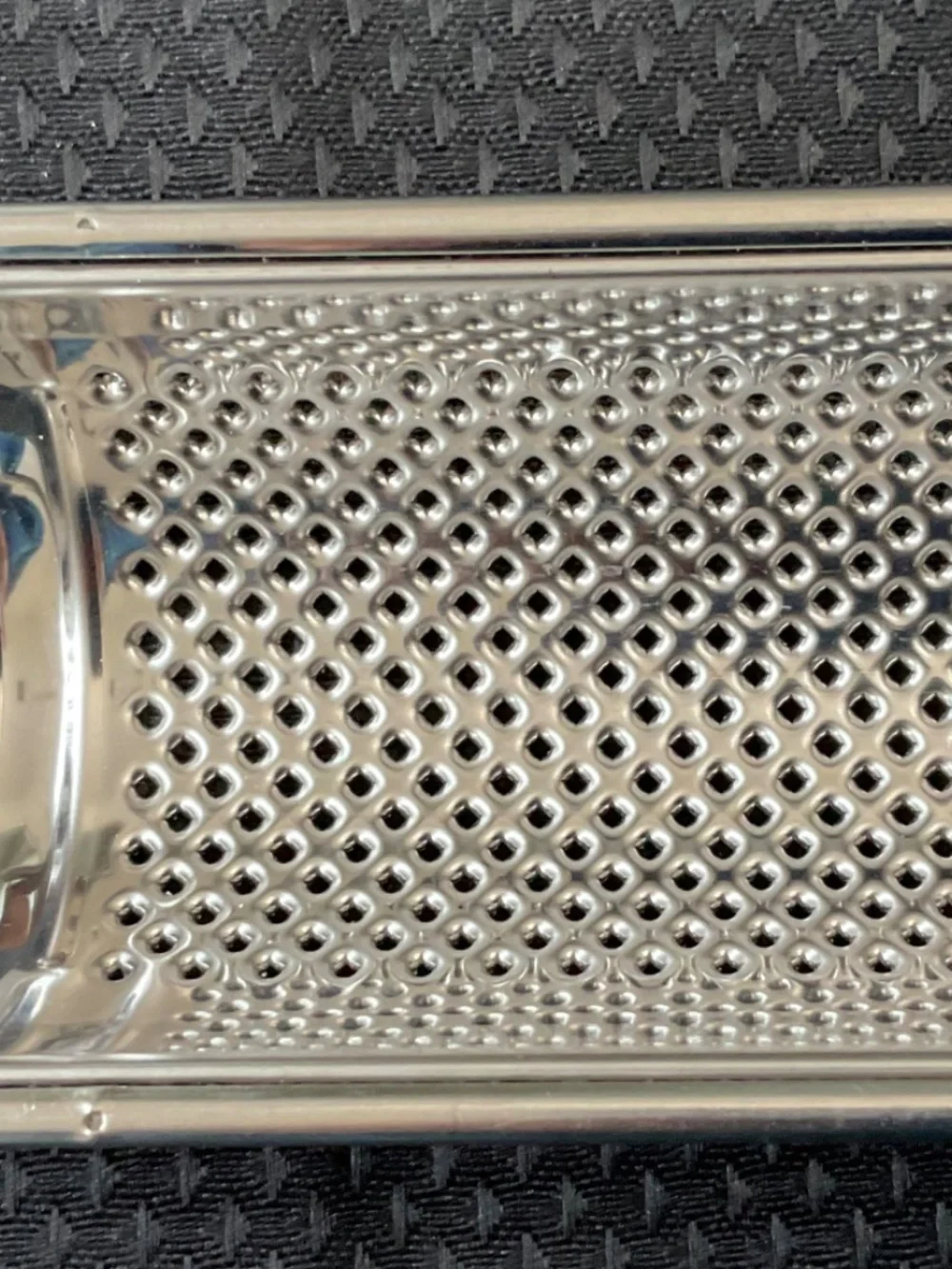 Stainless handled grater also has hole for hanging.   8-1/4” long & 1-5/8” wide.